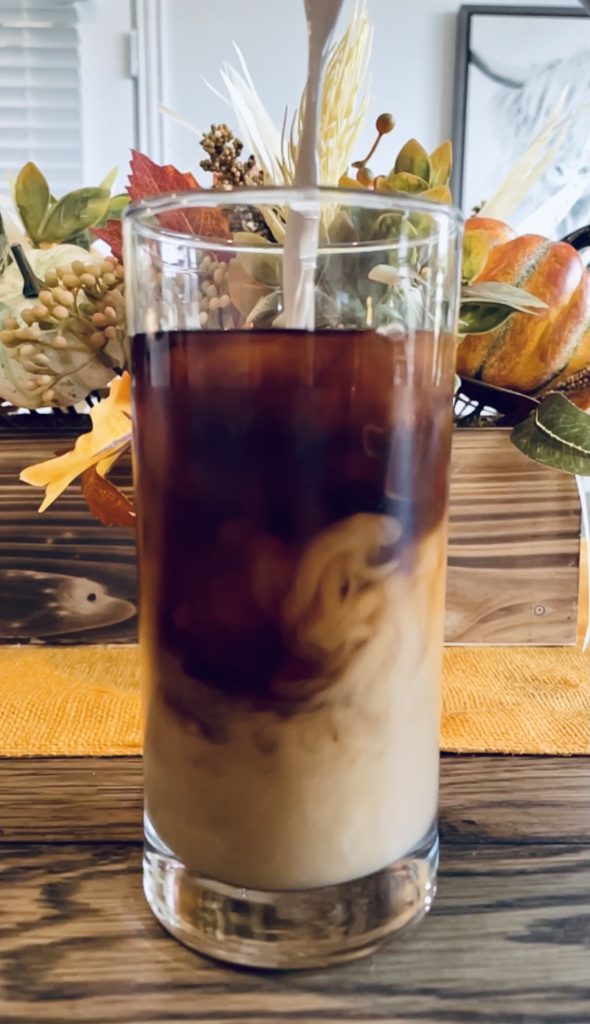 Cold Brew Coffee in Glass with Oat Milk being Poured 