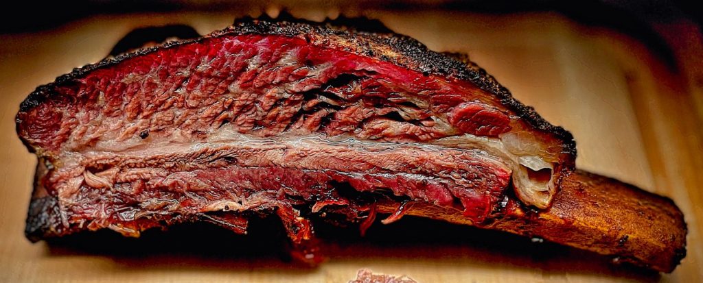 Sliced individual beef plate rib on cutting board