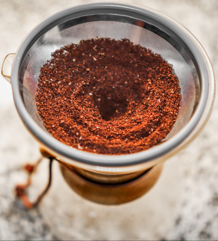 Ground up coffee in metal filter on Chemex